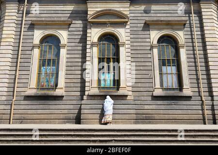 Frau mit äthiopischer Kleidung, die ihren Glauben in der St. George's Cathedral, einer äthiopisch-orthodoxen Kirche in Addis Abeba, Äthiopien, zeigt. Stockfoto