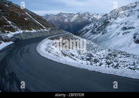 Schwarzer Asphalt mit Serpentinen und Schnee in den ötztal Bergen in österreich aus einer höheren Perspektive Stockfoto