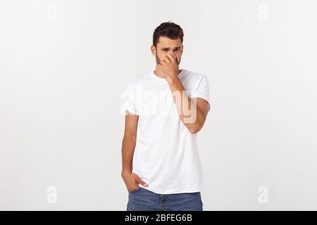 Nahaufnahme des enttäuschten gestressten bärtigen jungen Mannes im Hemd über weißem Hintergrund. Stockfoto