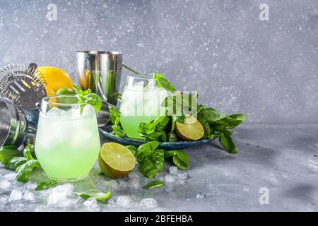 Basil Smash Gin alkoholischen Cocktail. Lange Alkohol trinken Rezept mit frischen Basilikumblättern und Limetten, grauen Stein Hintergrund kopieren Raum Stockfoto