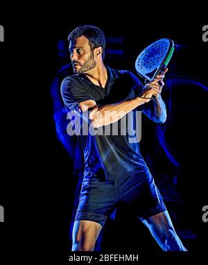Eine kaukasische Paddle tennis player Mann studio Schuß auf schwarzen Hintergrund mit Licht malen blur Effekt isoliert Stockfoto