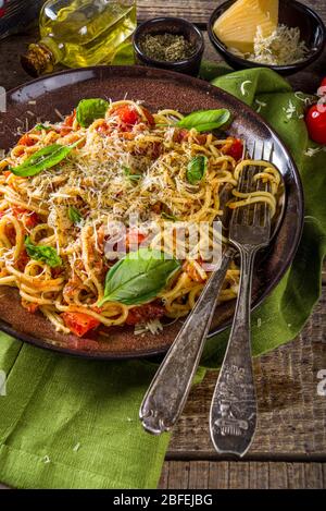 Traditionelle italienische Pasta Marinara. Klassisches Rezept Römisches Essen - Pasta bucatini amatricana, mit Basilikumblättern auf rustikalem Holzhintergrund Stockfoto