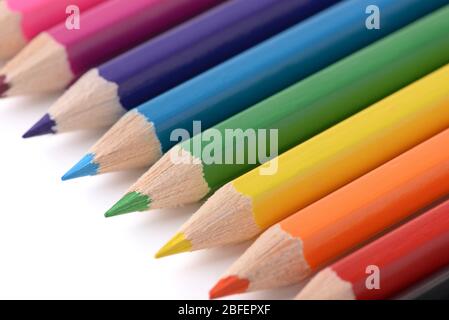 Nahaufnahme von mehrfarbigen Bleistiften in Reihe auf weißem Hintergrund Stockfoto