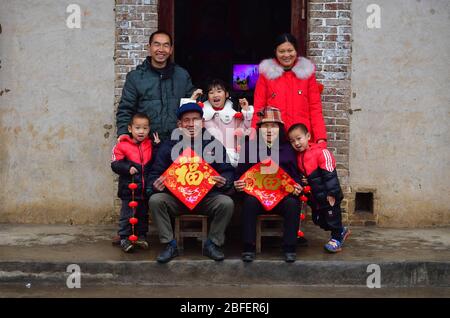 (200418) -- LUZHAI, 18. April 2020 (Xinhua) -- Pan Wenmings Familie posiert für Fotos zu Hause vor dem Frühlingsfest im Dorf Tunqiu der Gemeinde Pingshan im Landkreis Luzhai, Südchina, Guangxi Zhuang Autonome Region, 21. Januar 2020. Pan Wenming, 44, Vater einer 7-jährigen Tochter und 5-jährigen Zwillingssöhne, brachte die ganze Familie durch harte Arbeit aus der Armut in einem kleinen Bergdorf in Guangxi. Nachdem er über zehn Jahre außerhalb seiner Heimatstadt gearbeitet hatte, kehrten Pan und seine Frau 2012 zurück, weil sie sich um seine älteren Eltern kümmern und ein Unternehmen gründen sollten. Sie setzen ihre harte Stockfoto