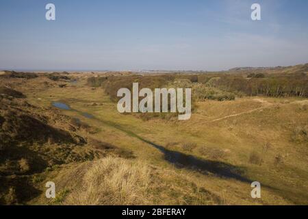 Weite Sicht von oben im Merthry Mawr Naturschutzgebiet Richtung Porthcawl in der Ferne mit vorübergehendem See im Vordergrund Stockfoto