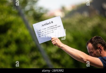 18. April 2020, Baden-Württemberg, Stuttgart: "Artikel 8 - (1) Alle Deutschen haben das Recht, sich friedlich und ohne Waffen ohne Registrierung oder Erlaubnis zu versammeln" steht auf einem Zeichen eines Teilnehmers einer Demonstration gegen die Grundrechtsbeschränkungen in Zeiten der Corona-Krise. Die Stadt Stuttgart hat nach einer Entscheidung des Bundesverfassungsgerichts grünes Licht für die Demonstration gegeben, die sie zunächst verboten hat. Die Versammlung konnte stattfinden, wenn ein Abstand von 1.5 Metern zwischen den Teilnehmern und ein Abstand zu den Passanten von 2 Metern beobachtet wurde. Foto: Chr. Stockfoto