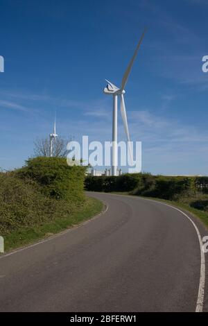 Zwei der Strom erzeugenden Windkraftanlagen stürmen auf dem Boden, dem Gelände eines stillgehaltenen Flugplatzes Stockfoto