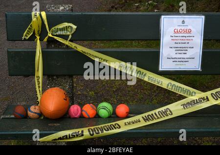 17. April 2020 - verlassene Spielzeugkugeln für Kinder liegen auf einer Bank, die mit Klebeband umwickelt ist, in einem Park in der Stadt View Royal, einer der Gemeinden Stockfoto