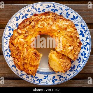 Köstliche hausgemachte Apfel-und Mandelkuchen auf verzierten weißen Teller und Holzhintergrund Stockfoto