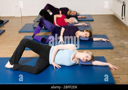 Eine Übungsklasse im Body Control Center in London übt die Pilates Oyster Position. Pilates ist das körperliche Fitness-System in der e entwickelt Stockfoto