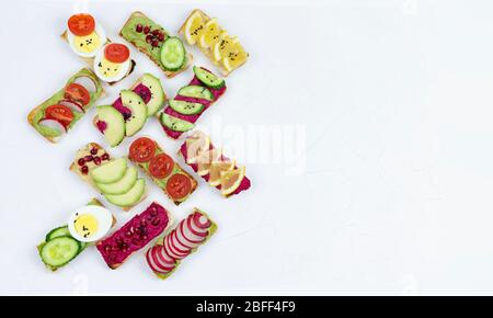 Set verschiedene Bruschetta Sandwiches mit Rübenhummus, Guacamole, verschiedene Gemüse. Vegetarisches Helsifood-Konzept. Sommernack. Food patern auf whit Stockfoto