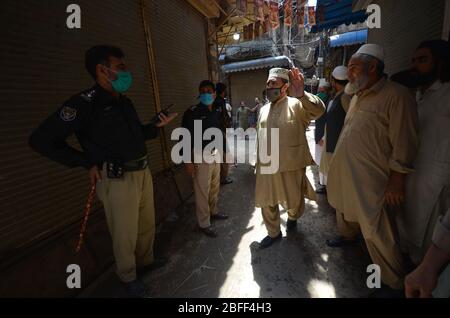 Peshawar, Pakistan. April 2020. Polizeibeamte schließen Geschäfte in der Stadt für Vorsichtsmaßnahmen, um die Ausbreitung des Corona-Virus zu verhindern. (Foto: Hussain Ali/Pacific Press) Quelle: Pacific Press Agency/Alamy Live News Stockfoto