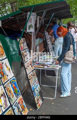 Frau mit orangefarbenen Haaren beim Stöbern in den Bouquinistes von Paris (Pariser Bücherstände), am linken Ufer der seine in Paris - Genenale Szenen von paris Stockfoto