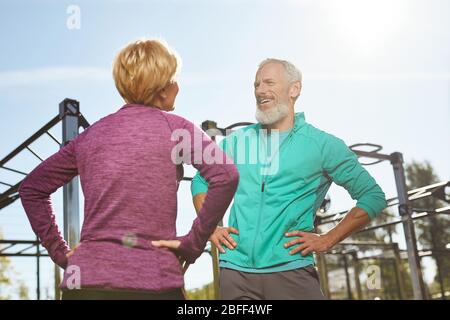 Morgenübungen. Glückliche ältere Familie Paar in Sportkleidung Gymnastik zusammen im Outdoor-Fitnessstudio. Mann und Frau, die Sport im Freien treiben Stockfoto