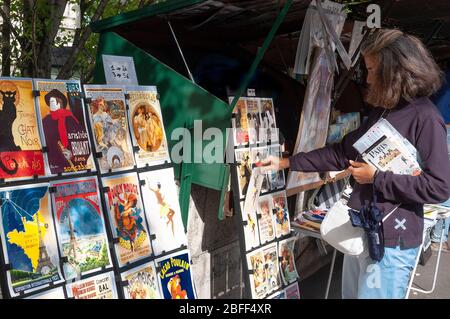 Frau beim Stöbern in den Bouquinistes von Paris (Pariser Buchstände), am linken Ufer der seine in Paris - Genenale Szenen von Paris Stockfoto