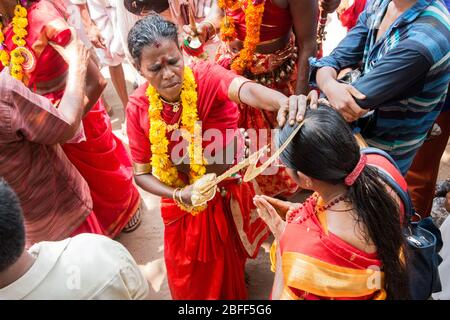 Anhänger im roten Kleid und Sickleshaped Schwerter am Sree Kurumba Sree Kurumba Bhagwati Tempel Kodungallur, während Bharani Festival, Thrissur, Kerala, Indien Stockfoto