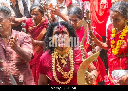 Anhänger im roten Kleid und Sickleshaped Schwerter am Sree Kurumba Sree Kurumba Bhagwati Tempel Kodungallur, während Bharani Festival, Thrissur, Kerala, Indien Stockfoto