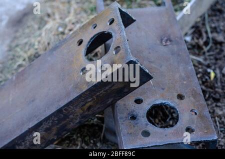Bohrungen in Metallkanälen. Zwei massive Metallteile mit je sieben Strukturlöchern. Industrieller Hintergrund. Nahaufnahme. Selektiver Fokus. Stockfoto