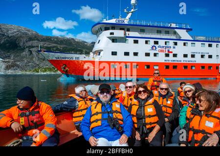 Touristen von Skorpios III fahren am El Brujo Gletscher am Rand des Sarmiento Kanals im Bernardo O'Higgins Nationalpark in Patagonien Chile Fjorde Stockfoto