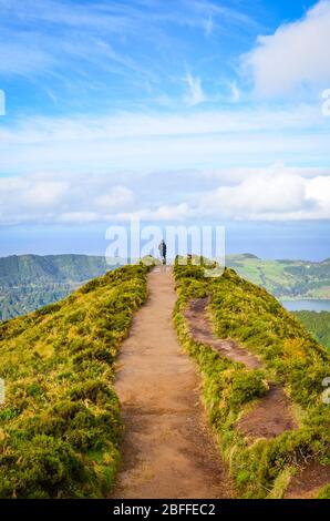 Ein Weg zum Aussichtspunkt Miradouro da Boca do Inferno in Sao Miguel Insel, Azoren, Portugal. Erstaunliche Kraterseen umgeben von grünen Feldern und Wäldern. Tourist am Ende der landschaftlich schönen Weg. Stockfoto
