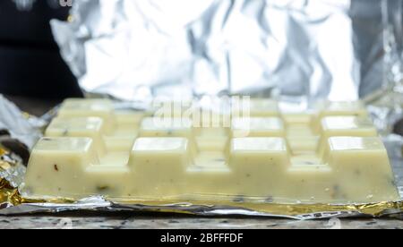 Weiße Schokolade Block Nahaufnahme. Das Paket hat eine geöffnete Aluminiumfolie. Stockfoto