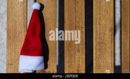 Weihnachtsmann Hut auf einer hölzernen Sonnenliege in der Nähe des Pools. Weihnachtsferien. Frohes neues Jahr Hintergrund. Kopieren Raum. Stockfoto