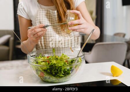 In der Nähe gießen Sie die Soße Tropfen auf den Salat Stockfoto