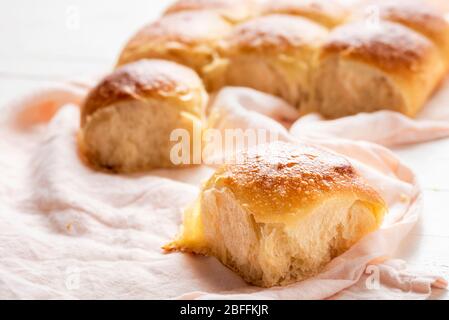 Brotbrötchen aus Weißmehl und Sauerteig auseinanderziehen. Leckere selbstgebackene Brötchen. Weißbrot mit goldener Kruste Nahaufnahme Stockfoto