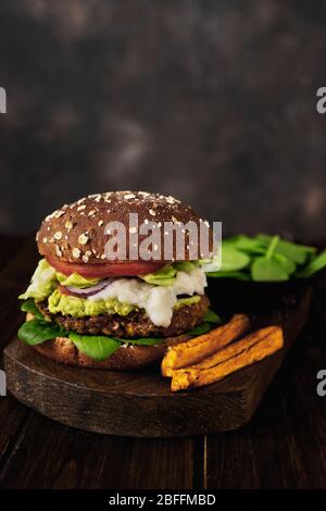 Vertikale Aufnahme von veganen Linsen Burger und Süßkartoffel Stockfoto