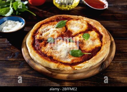 Hausgemachte vegane Margherita Pizza auf rustikalem Holzhintergrund Stockfoto