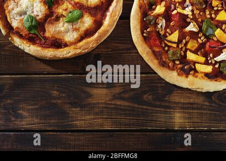 Flaches Lay von zwei veganen Pizzas auf dunklem rustikalem Hintergrund Stockfoto