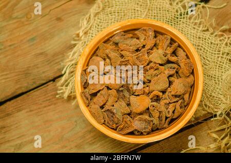 Getrocknete Aprikosen in Schüssel. Köstliche getrocknete Aprikosen. Schüssel mit getrockneten Aprikosen. Getrocknete Aprikosen auf Holzhintergrund. Draufsicht mit Kopierbereich. Stockfoto