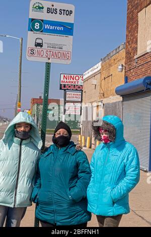 Detroit, Michigan, USA. April 2020. Detroit Bewohner tragen Masken während sie auf einen Stadtbus warten. Busse fahren wegen der Coronavirus-Pandemie viel seltener in der Stadt. Kredit: Jim West/Alamy Live News Stockfoto