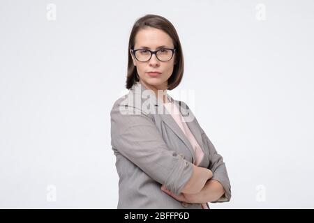 Attraktive kaukasische lächelnde Frauenbrille ernsthaft auf Kamera isoliert auf weißen Studio-Aufnahme suchen Stockfoto