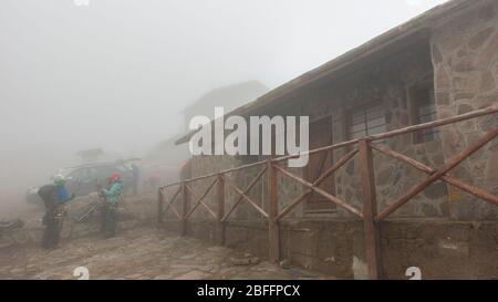 Cayambe, Pichincha / Ecuador - Februar 24 2020: In Kletterausrüstung gekleidete Personen stehen neben der Ruales Oleas Berge Hütte, die sich neben der Ca Stockfoto