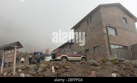 Cayambe, Pichincha / Ecuador - Februar 24 2020: Eine Gruppe von Touristen, die in der Nähe der Ruales Oleas Berge Hütte neben dem Vulkan Cayambe spazieren Stockfoto