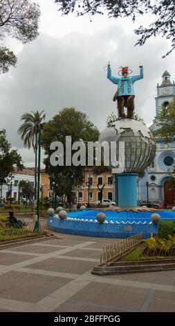 Cayambe, Pichincha / Ecuador - Februar 24 2020: Menschen sitzen im zentralen Park der Stadt mit der Matriz-Kirche im Hintergrund Stockfoto