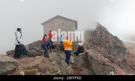 Cayambe, Pichincha / Ecuador - Februar 24 2020: Gruppe von Touristen, die die Landschaft des Cayambe Vulkans in der Nähe der Ruales Oleas Berge Hütte betrachten Stockfoto