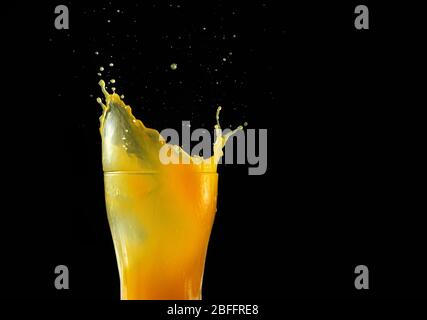 Orangensaft wird aus einem Glas verschüttet Stockfoto