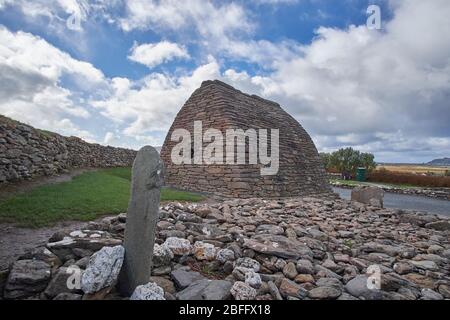 Außenansicht des Gallarus Oratoriums in Dingle Peninsula County Kerry Irland mit dem Colum Mac Dinet Stein im Vordergrund. Stockfoto