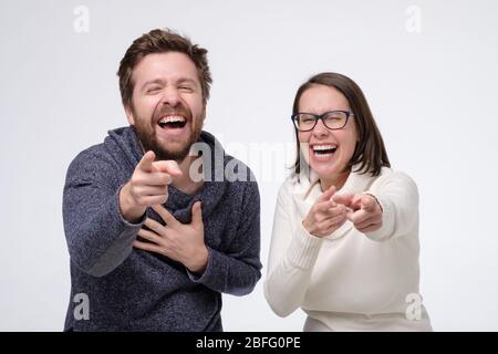 Glückliches Paar kaukasischen reifen Mann und Frau lachen zeigt auf Ihren Witz. Studioaufnahme Stockfoto