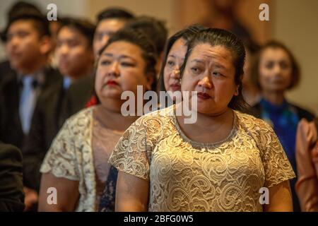 Vietnamesische amerikanische Hochzeitsgäste beobachten die Ankunft der Braut bei einer Hochzeit in einer katholischen Kirche in Südkalifornien. Stockfoto