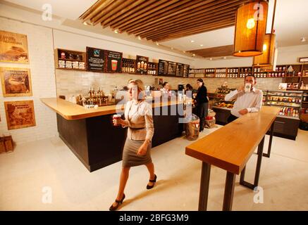Ein Starbucks Barista serviert morgen Kaffee im neuen Look, der bei Starbucks in der Conduit Street, London eröffnet wird. Der neue Store ist einer von mehreren Store Desi Stockfoto