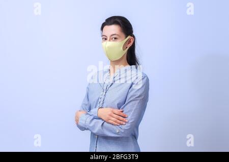 Mädchen in einer schützenden medizinischen Maske. Prävention von Viruserkrankungen der Erkältung und Grippe. Hellblauer Hintergrund. In einer Atemmaske. Das Konzept des Schutzes gegen das Virus. Stockfoto