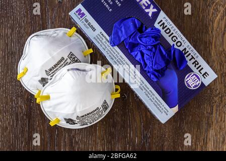 BELLEVUE, WA/USA – 18. APRIL 2020: PSA-Sicherheitszubehör auf Holztisch, N95-Maske und Nitrilhandschuhe zum Einweg Stockfoto