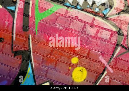 Abstraktes buntes Fragment von Graffiti-Gemälden auf alten Ziegelwänden. Street Art Komposition mit Teilen von wilden Buchstaben und bunten Flecken. Subkult Stockfoto