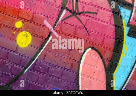 Abstraktes buntes Fragment von Graffiti-Gemälden auf alten Ziegelwänden. Street Art Komposition mit Teilen von wilden Buchstaben und bunten Flecken. Subkult Stockfoto