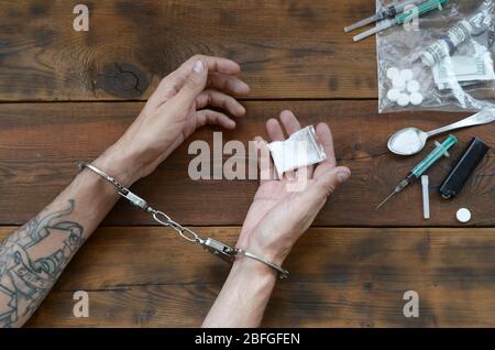 Drogenhändler wurden zusammen mit ihrem Heroin verhaftet. Die Polizei verhaftete den Drogenhändler mit Handschellen. Gesetz und Polizei Konzept für Welt Anti-Drogen-Tag. 26 J Stockfoto