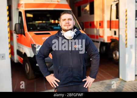 Bad Krozingen, Deutschland. April 2020. Simon Manninger (26), Notarzt des DRK, steht zu Beginn seiner Nachtschicht vor der Fahrzeughalle der Rettungsstation. Er ist in der Notrettung tätig und wird sowohl als Fahrer des Rettungswagens (NEF) als auch im Rettungswagen (RTW) eingesetzt. (Zu dpa: 'Simon Manninger kann bei der Rettung nicht Abstand halten') Quelle: Philipp von Ditfurth/dpa/Alamy Live News Stockfoto