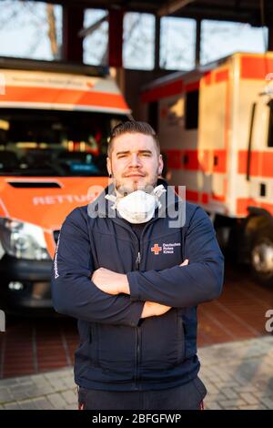 Bad Krozingen, Deutschland. April 2020. Simon Manninger (26), Notarzt des DRK, steht zu Beginn seiner Nachtschicht vor der Fahrzeughalle der Rettungsstation. Er ist in der Notrettung tätig und wird sowohl als Fahrer des Rettungswagens (NEF) als auch im Rettungswagen (RTW) eingesetzt. (Zu dpa: 'Simon Manninger kann bei der Rettung nicht Abstand halten') Quelle: Philipp von Ditfurth/dpa/Alamy Live News Stockfoto